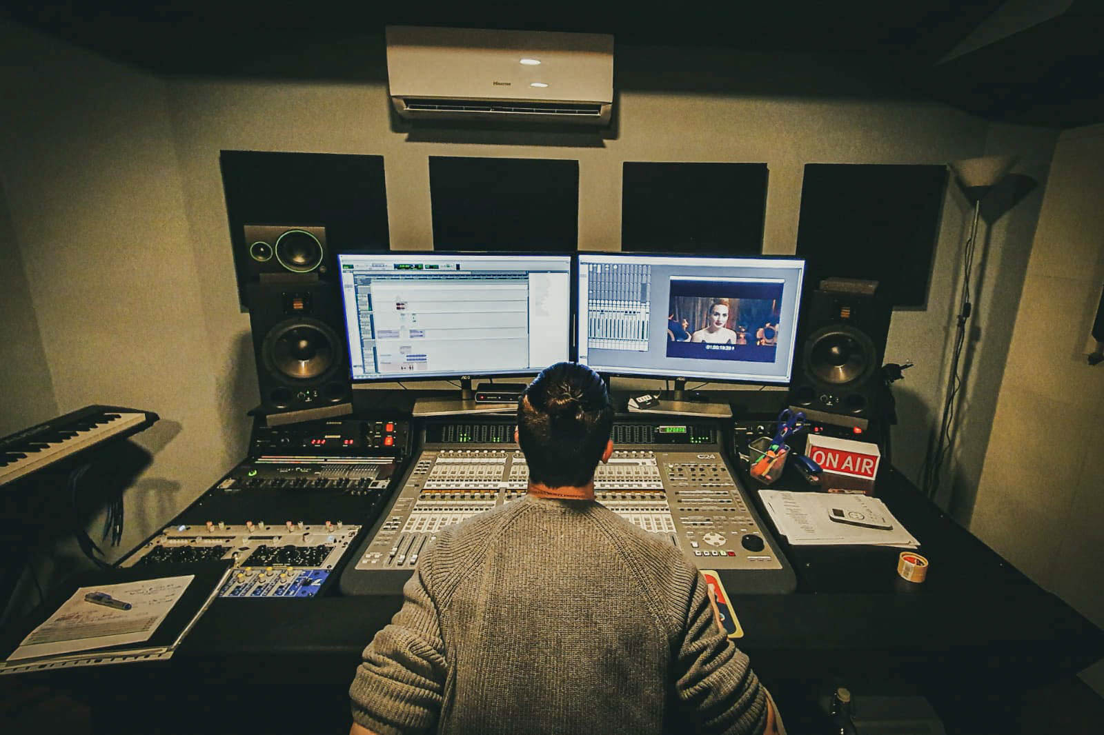 Sala de control con mesa de mezclas y productor trabajando en MainTrack Studio, Barcelona.
