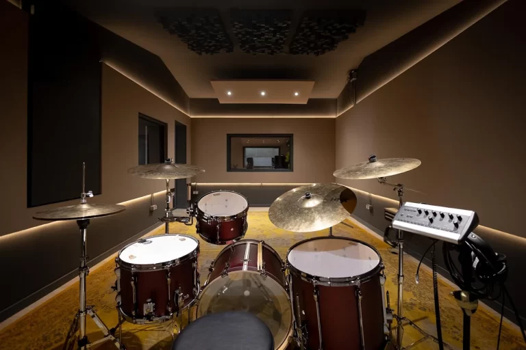 Sala de grabación de Estudi Local en Barcelona con batería, tratamiento acústico y vistas a la sala de control