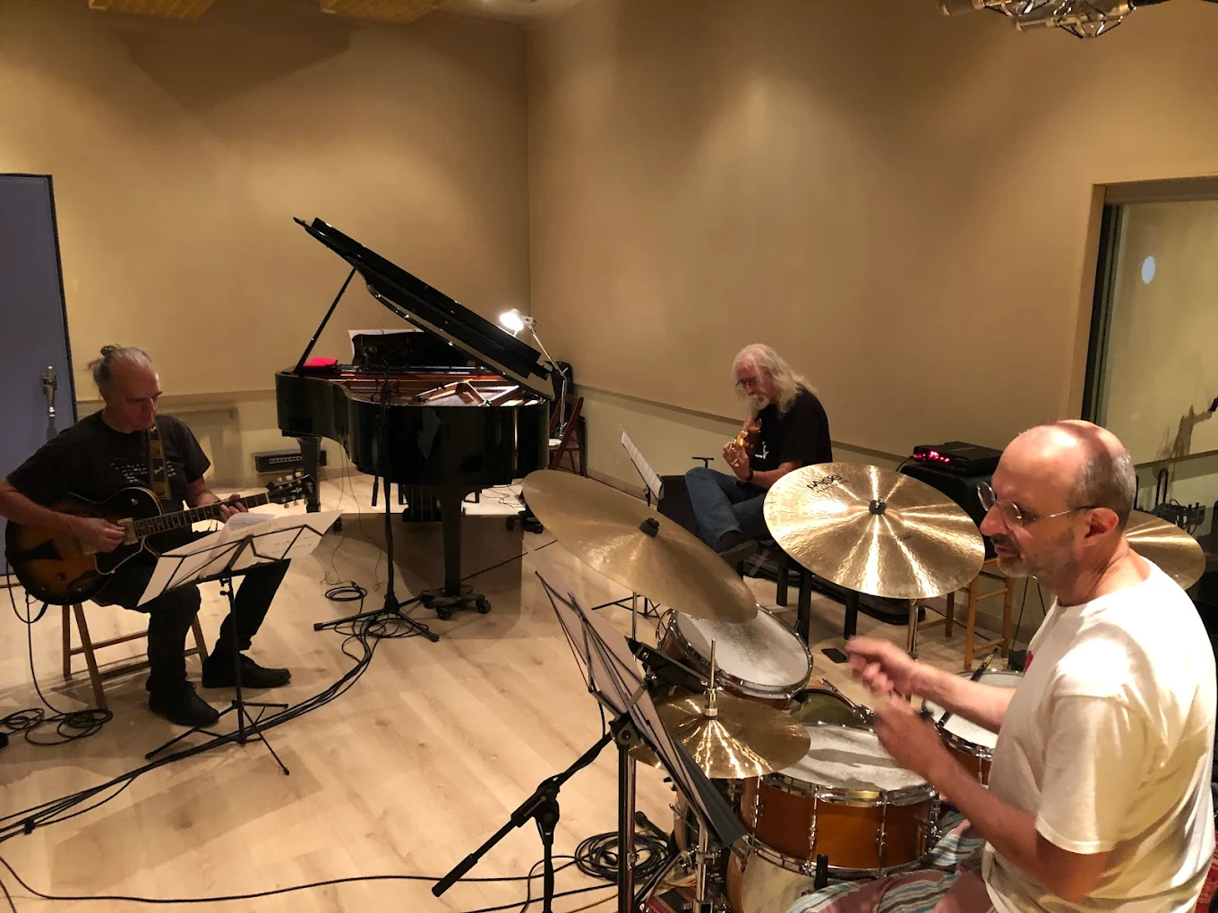 Estudio RosAzul, Barcelona — sala de grabación con tres músicos, batería y guitarras en sesión de ensayo.