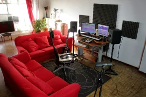 Sala de control In Wave Studio, Madrid, con dos sofás rojos alrededor de la mesa de control para artistas.