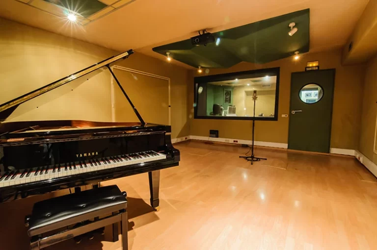 Sala de grabación con piano negro de cola y micrófono en KorylandSl, Barcelona.