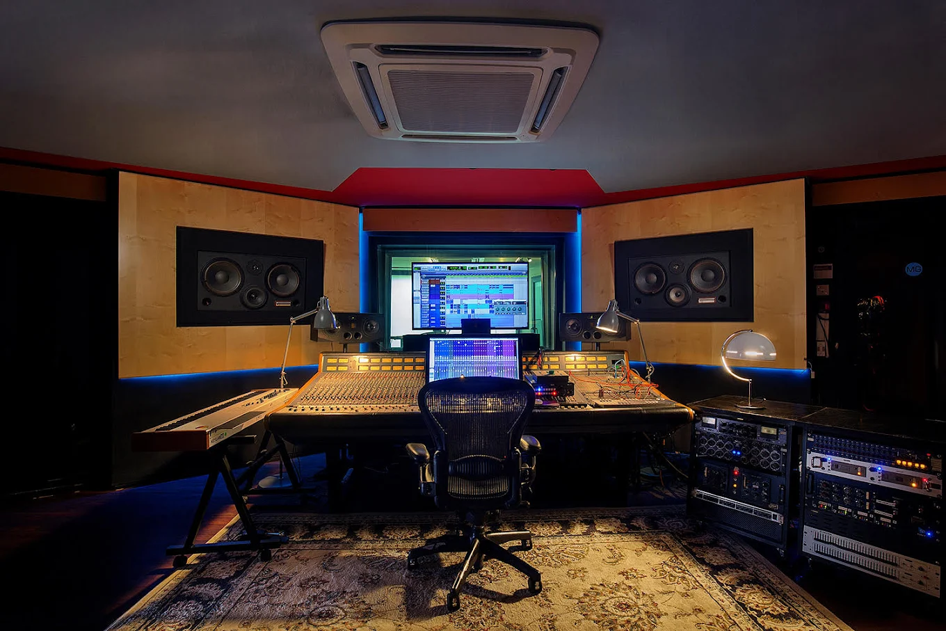 Sala de control de Mapa Studios en Madrid con mesa analógica, racks de efectos y monitores profesionales montados en la pared.