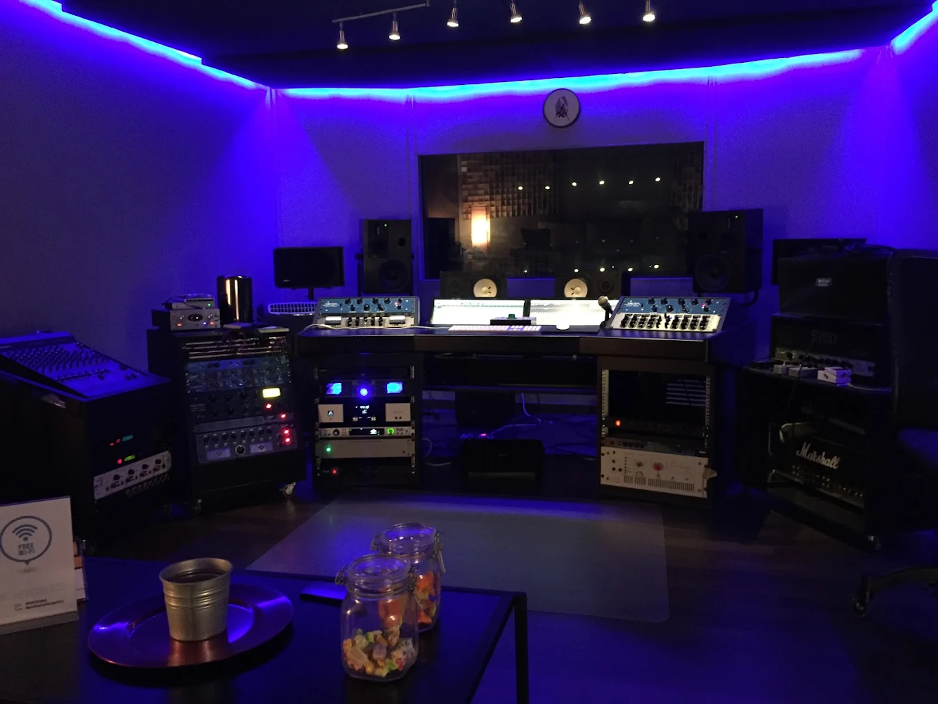 Sala de control Mpire Studio, Madrid, lista para producción musical con luz ambiente azul.