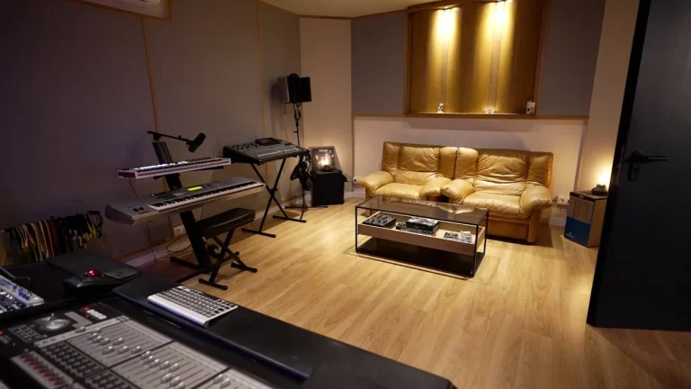 Estudio de grabación con sofá cómodo para artistas, diferentes teclados y mesa de mezclas en Sonic Art Studio, Barcelona.